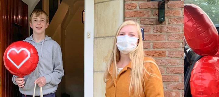 Eén van de leden van de Kinderadviesraad krijgt een goodiebag met ballon uit handen van een kinderverpleegkundige